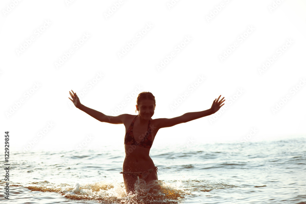 Silhouette of girl having fun in Baltic sea splashing waves Silhouette of girl having fun in Baltic sea splashing waves