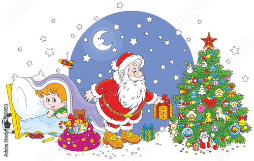The night before Christmas, Santa Claus putting his holiday gifts under a decorated tree for a little boy who spying behind him from under a blanket