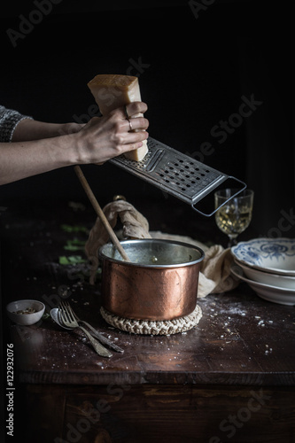 Grating Parmigiano Parmesan Cheese in Risotto Copper Pot