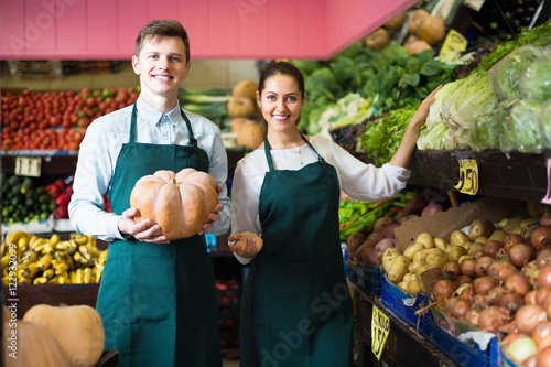 Sellers posing with big pumpkin