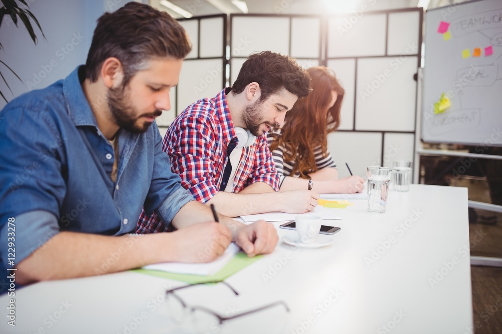 Business people writing on documents in meeting room Business people writing on documents in meeting room