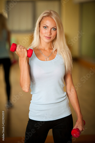 Fitness workout - fit woman training with dumbellc in gym