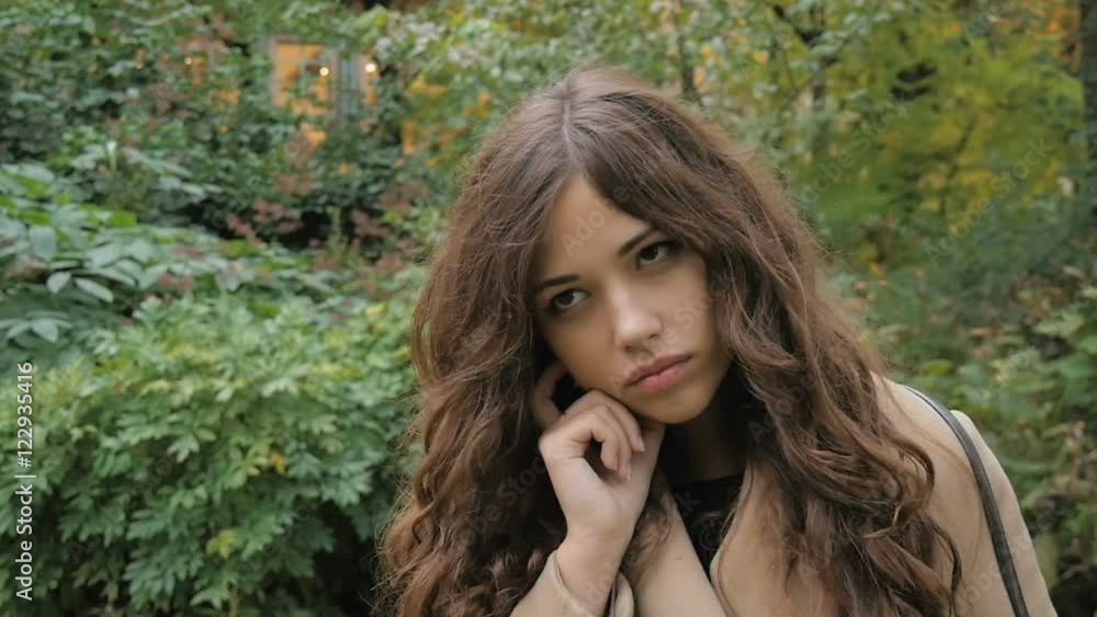 Beautiful girl is sad, in a park, slow motion Beautiful girl is sad, in a park, slow motion