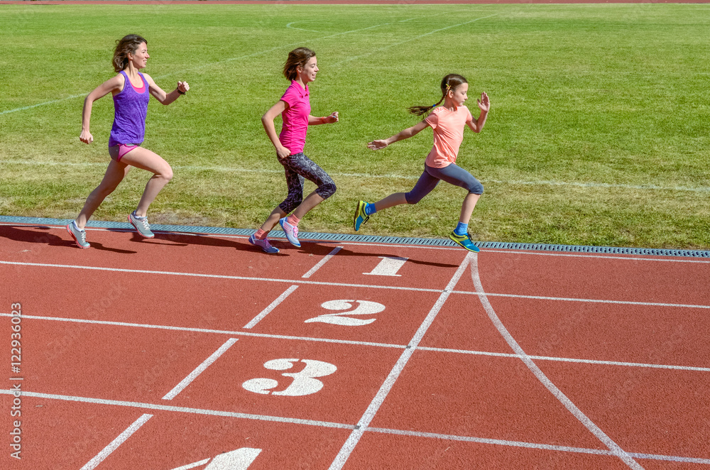 Family sport, mother and kids running on stadium track, training and children fitness concept

