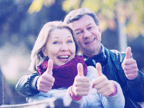 Smiling mature couple showing thumbs up