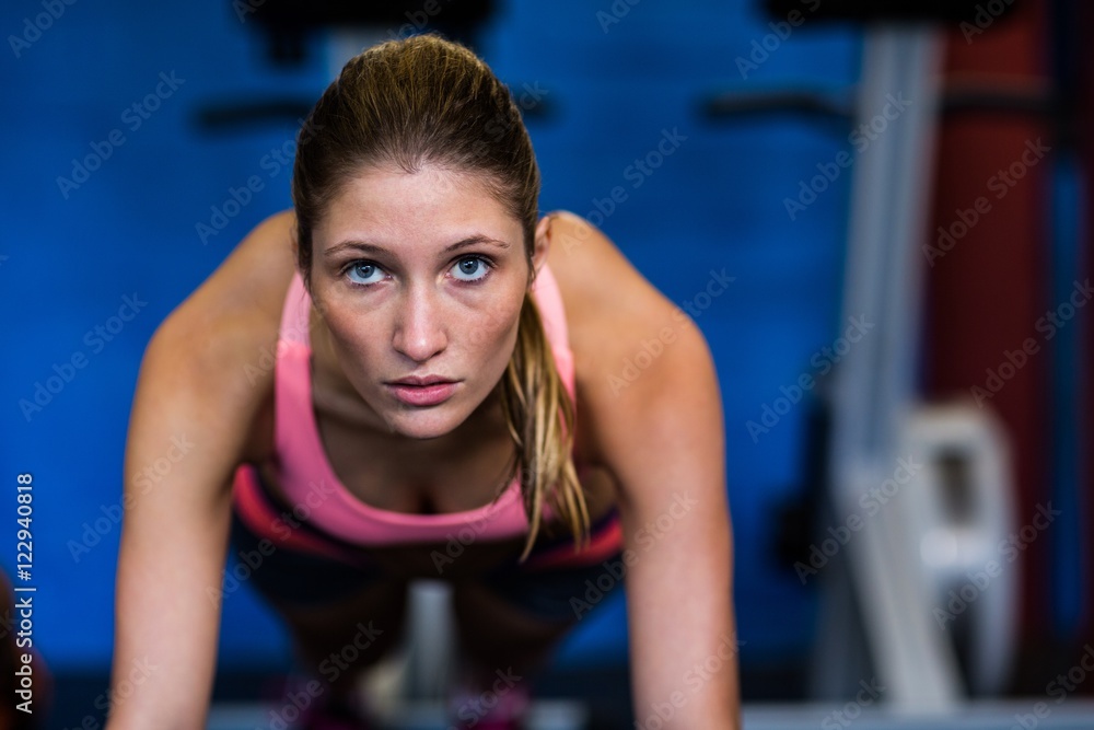 Determined female athlete doing push-ups Determined female athlete doing push-ups