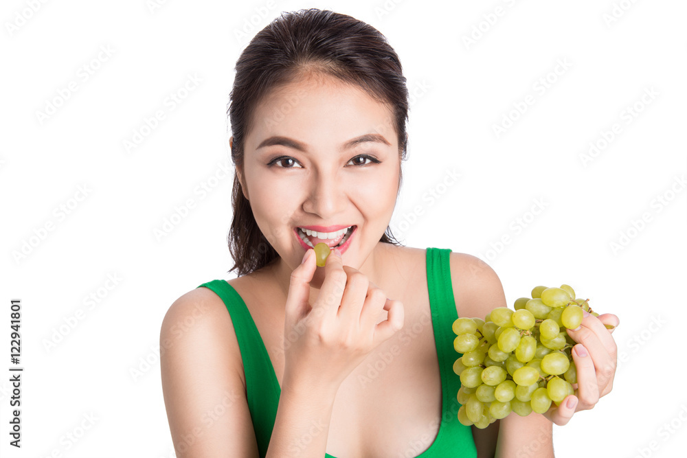 Young beautiful asian woman eating fresh grapes isolated on whit Young beautiful asian woman eating fresh grapes isolated on whit