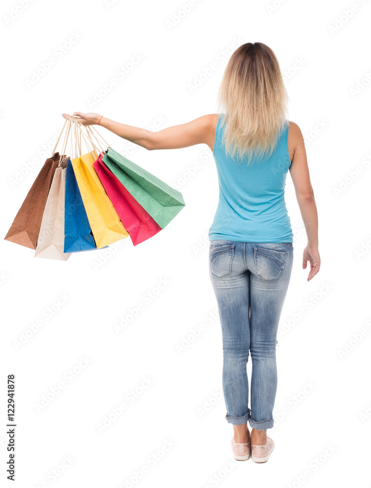 back view of woman with shopping bags . beautiful brunette girl in motion.  backside view of person.  Rear view people collection. Isolated over white background. The girl in a blue t-shirt standing