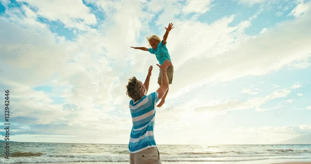 Father and son having fun on the beach at sunset, father throwing young boy up into the air Father and son having fun on the beach at sunset, father throwing young boy up into the air