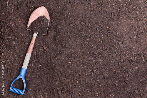 Little shovel partially covered in soil