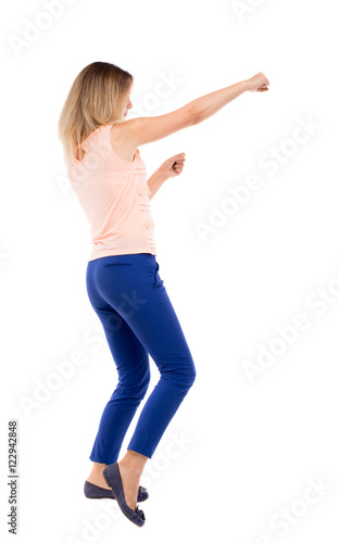 skinny woman funny fights waving his arms and legs. Isolated over white background. The blonde in a pink shirt boxing