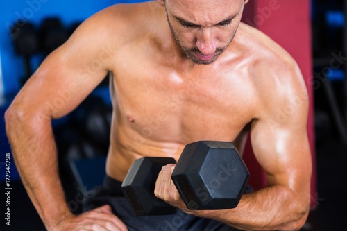 Male athlete holding dumbbell 