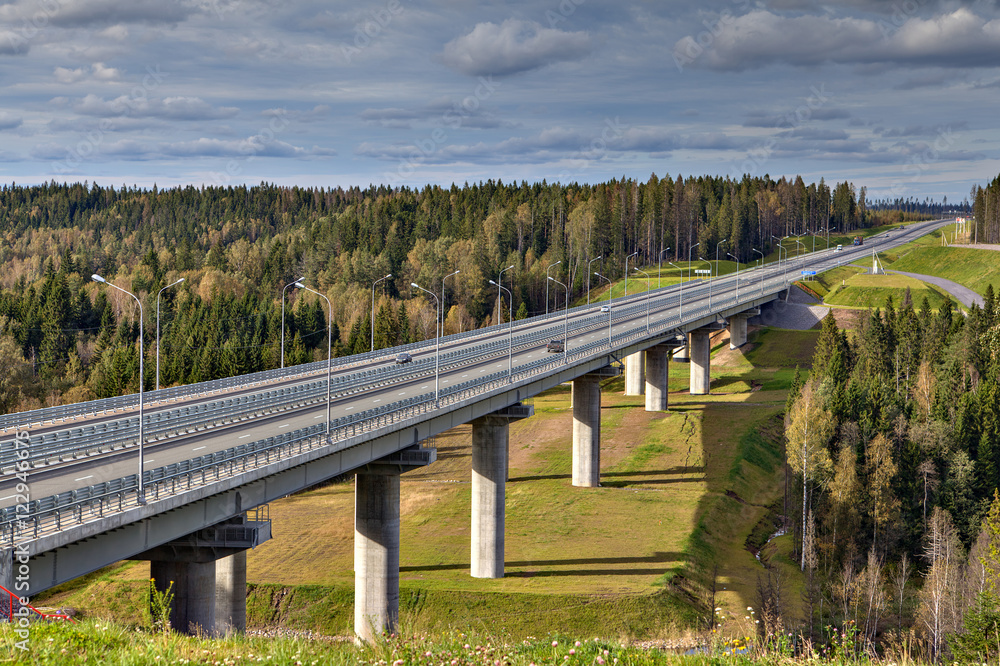 Steel bridge overpass on concrete piers, highway crosses Russian