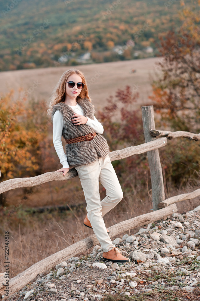 Stylish teen girl 13 14 year old posing at country side in modern