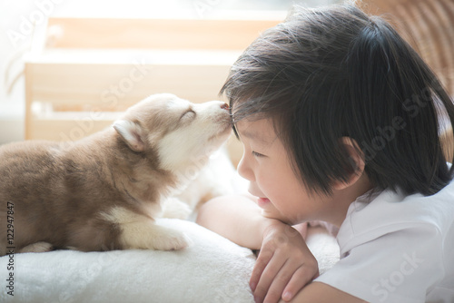 Papier peint asian child playing with siberian husky puppy