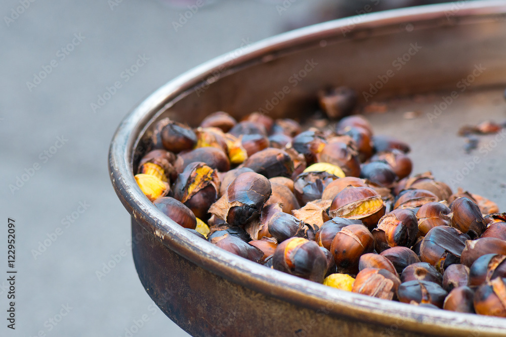 Grilled chestnuts for sale in a market stall Grilled chestnuts for sale in a market stall