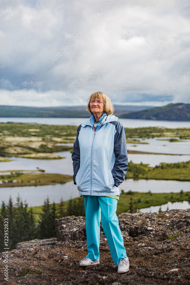 Senior woman is looking at Thingvellir National Park - Iceland