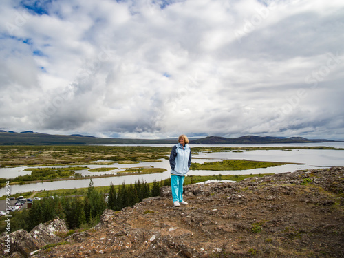 Senior woman is looking at Thingvellir National Park - Iceland