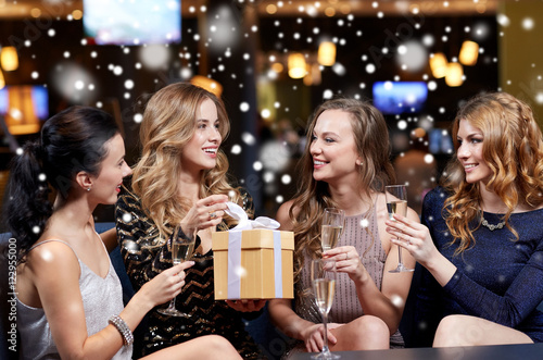 happy women with champagne and gift at night club