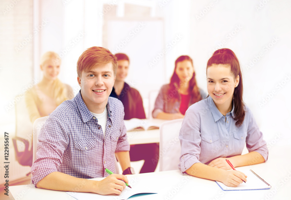 smiling students with notebooks at school smiling students with notebooks at school