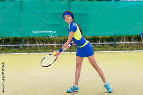 Young female tennis player wearing a sportswear playing tennis o © kolotype
