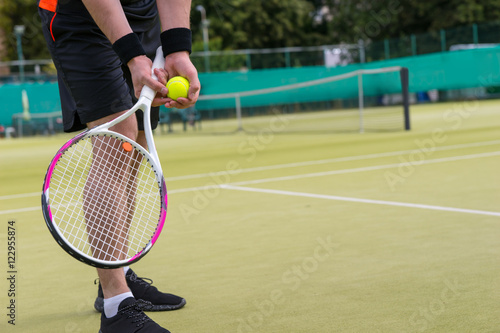 Close up male player's hand with tennis ball preparing to serve