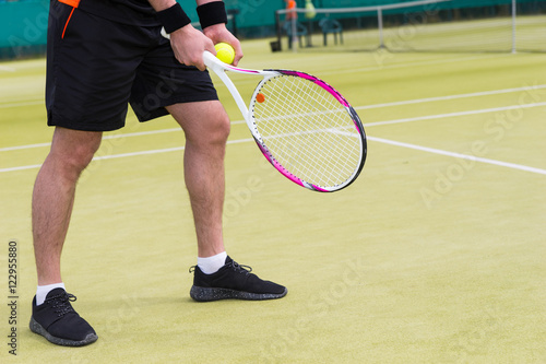 Close up male player's hand with tennis ball getting ready to se