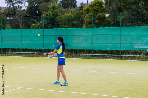 Sporty female tennis player wearing a sportswear warming up befo