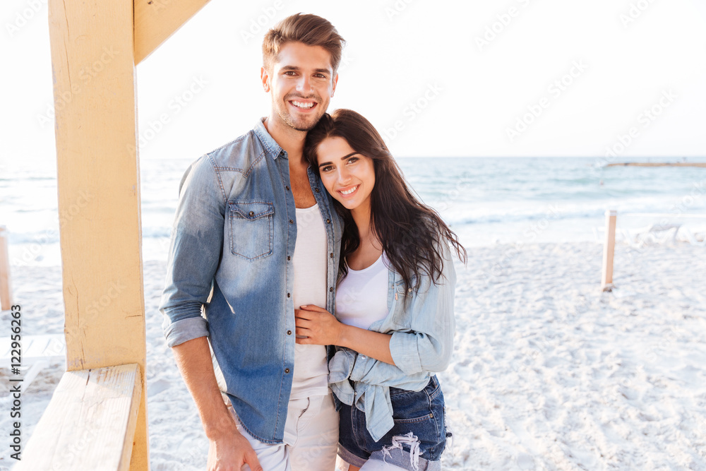 Beautiful young couple embracing on the beach Beautiful young couple embracing on the beach