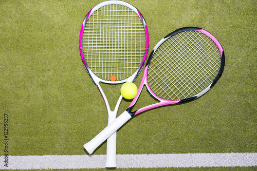 Close-up of two pink tennis rackets with a tennis ball © kolotype