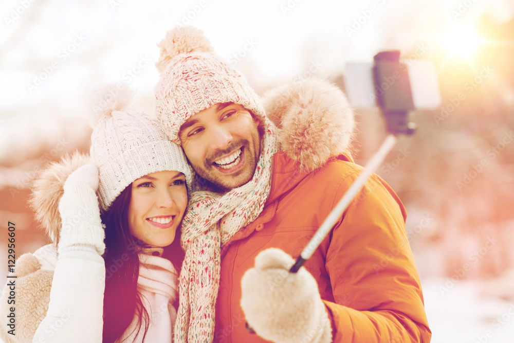 happy couple taking selfie by smartphone in winter happy couple taking selfie by smartphone in winter