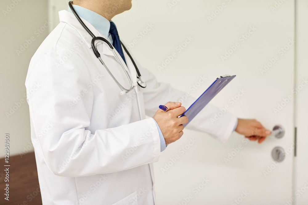 close up of doctor with clipboard at hospital door close up of doctor with clipboard at hospital door
