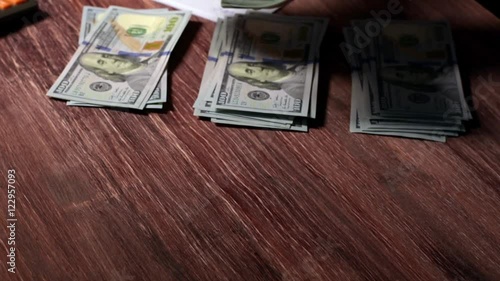 Woman arranged one hundred dollar bills into three stacks