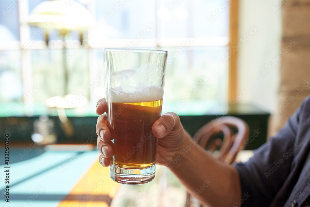 close up of man drinking beer at bar or pub