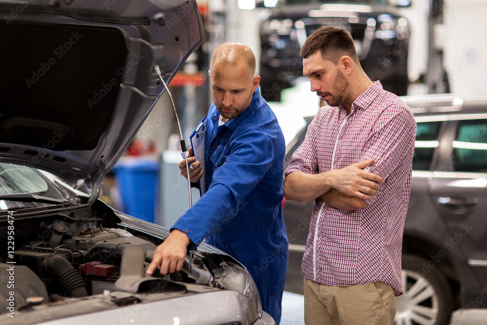 auto mechanic with clipboard and man at car shop auto mechanic with clipboard and man at car shop