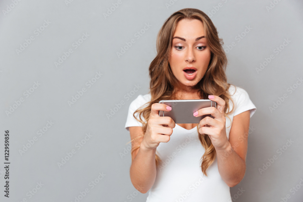 Surprised young woman looking on smartphone Surprised young woman looking on smartphone