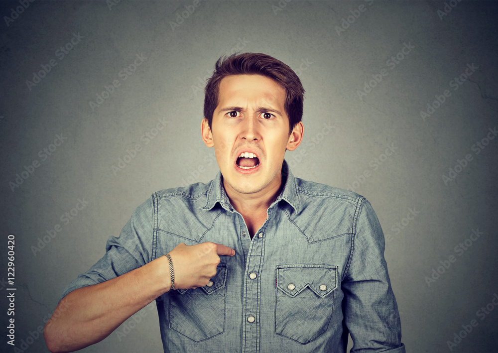 Angry, mad man pointing at himself asking you mean me? Stock Photo