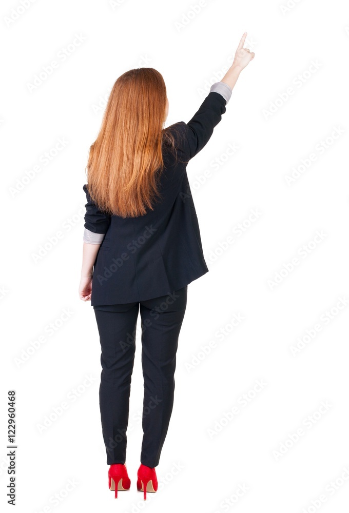Back view of young redhead business woman pointing at wal Back view of young redhead business woman pointing at wal