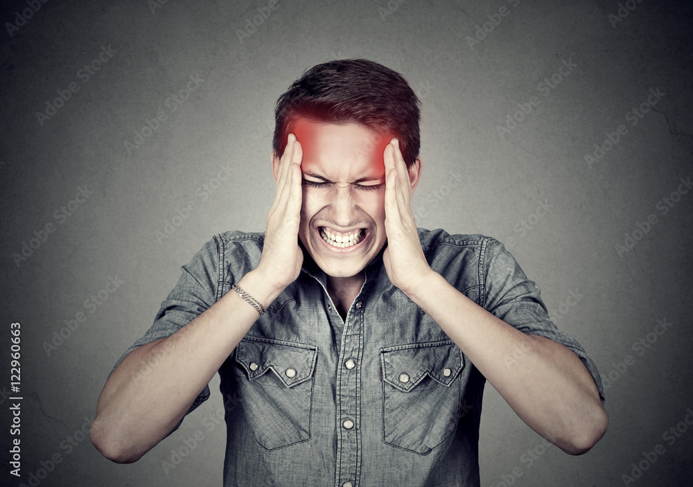 Stressed man with headache isolated on gray wall background Stressed man with headache isolated on gray wall background