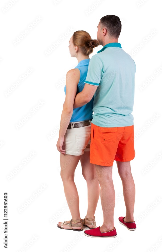 Back view of young embracing couple in shorts hug and look. friendly girl and guy together. Rear view people collection. backside view of person. Isolated over white background. Back view of young embracing couple in shorts hug and look. friendly girl and guy together. Rear view people collection. backside view of person. Isolated over white background.