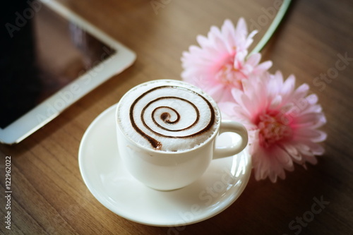 working with tablet and hot coffee cup flowers