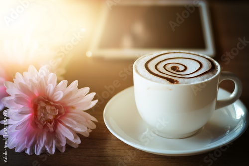 working with tablet and hot coffee cup flowers