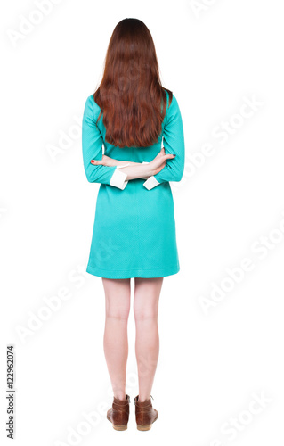 back view of standing young beautiful woman. girl watching. Rear view people collection. backside view of person. Isolated over white background. The girl in a blue dress with brown shoes is hand