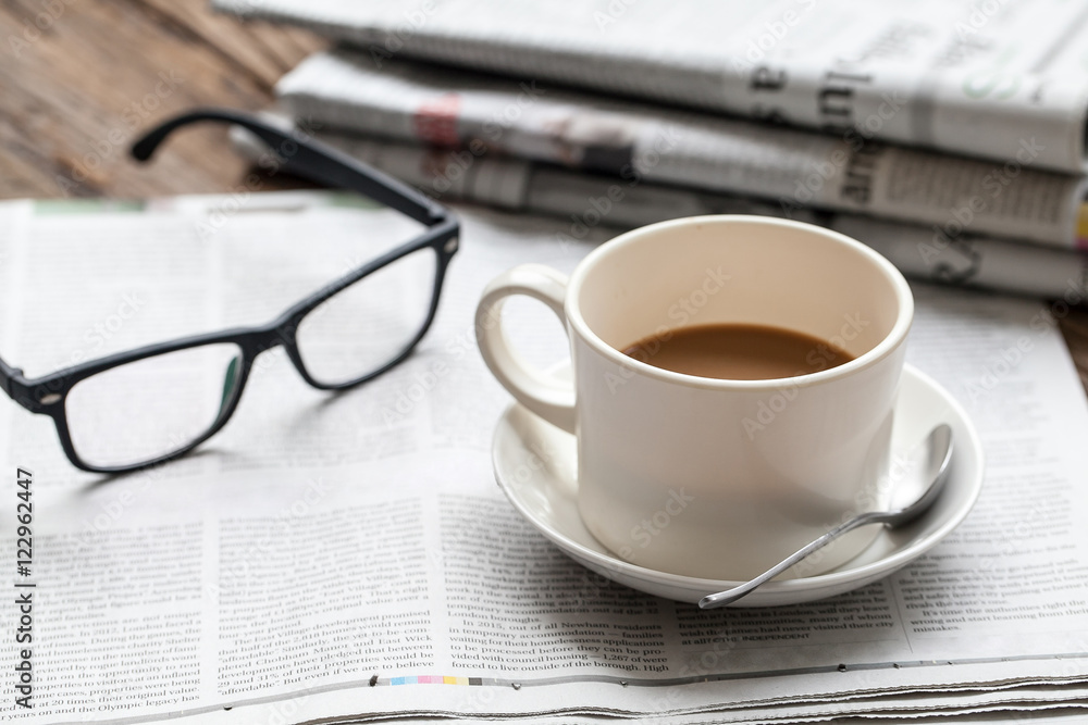 Coffee, glasses and newspapers on wooden table