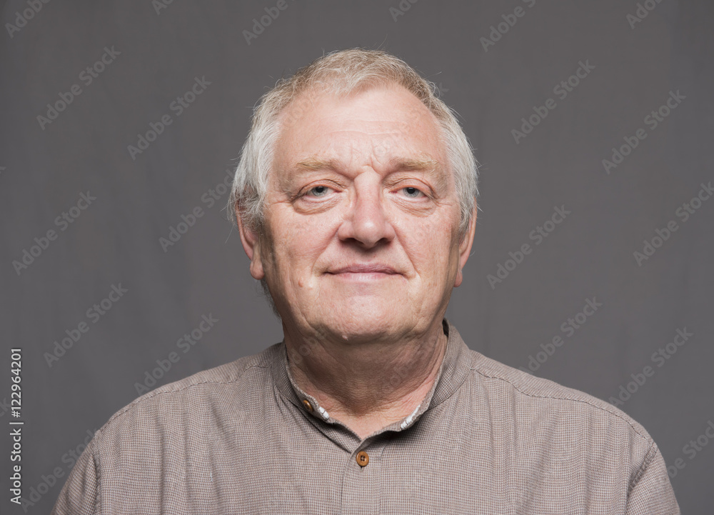 Portrait image of a mature man, looking into the camera. Taken on a grey background. Portrait image of a mature man, looking into the camera. Taken on a grey background.