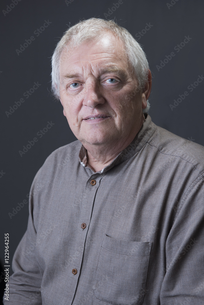 Portrait image of a mature man, looking into the camera. Taken on a grey background. Portrait image of a mature man, looking into the camera. Taken on a grey background.
