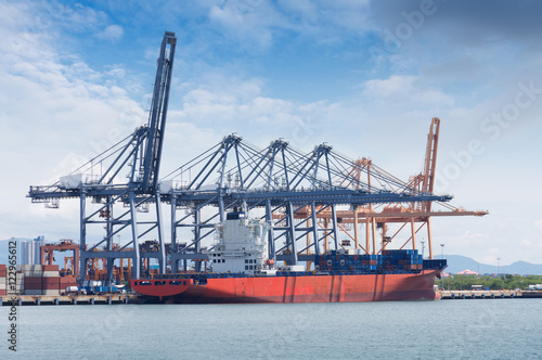 Logistics and transportation of International Container Cargo ship with ports crane bridge in harbor for logistic import export background and transport industry...