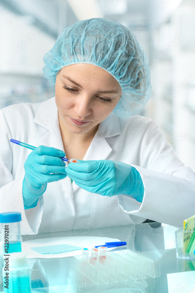 Young female scientist or tech labels test tubes Young female scientist or tech labels test tubes