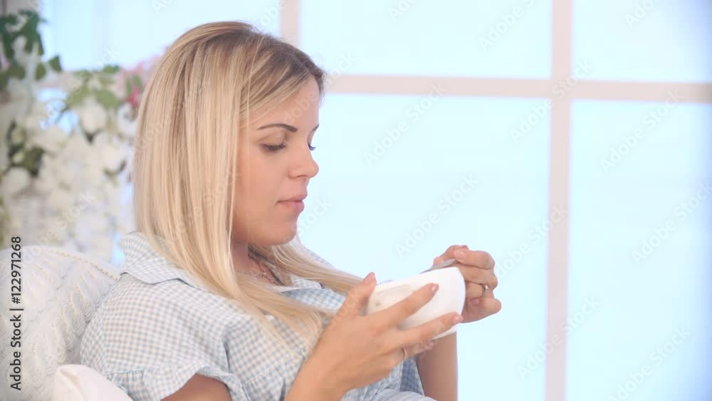 pregnant woman in blue dress eating healthy foods with a treat in the morning pregnant woman in blue dress eating healthy foods with a treat in the morning