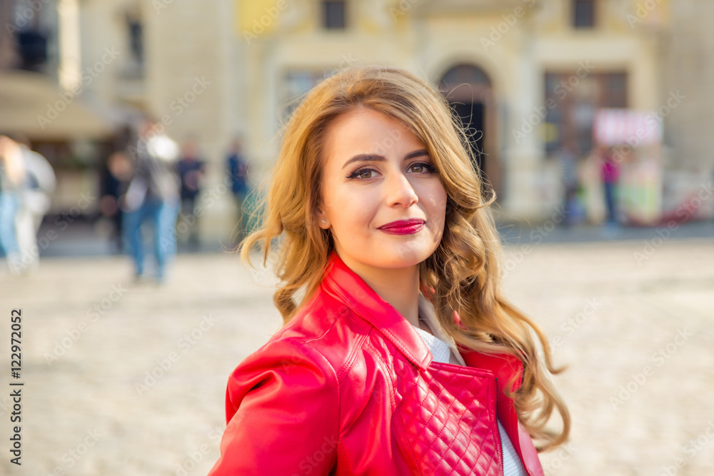 happy woman in a red jacket on sunny day